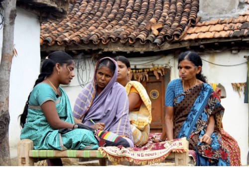 Bheema Mitras were appointed by the government to spread awareness on financial security and insurance practices among villagers. Clad in their blue saree uniforms, these women have a challenging task, sometimes visiting between 5 and 10 households a day where deaths have occurred. Seen here, a Bheema Mitra talks to a woman (who had lost her husband recently) about livelihood reintegration schemes and education loans for her children.